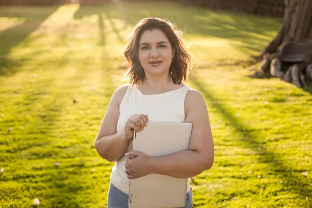 Woman holding a laptop in sunlight